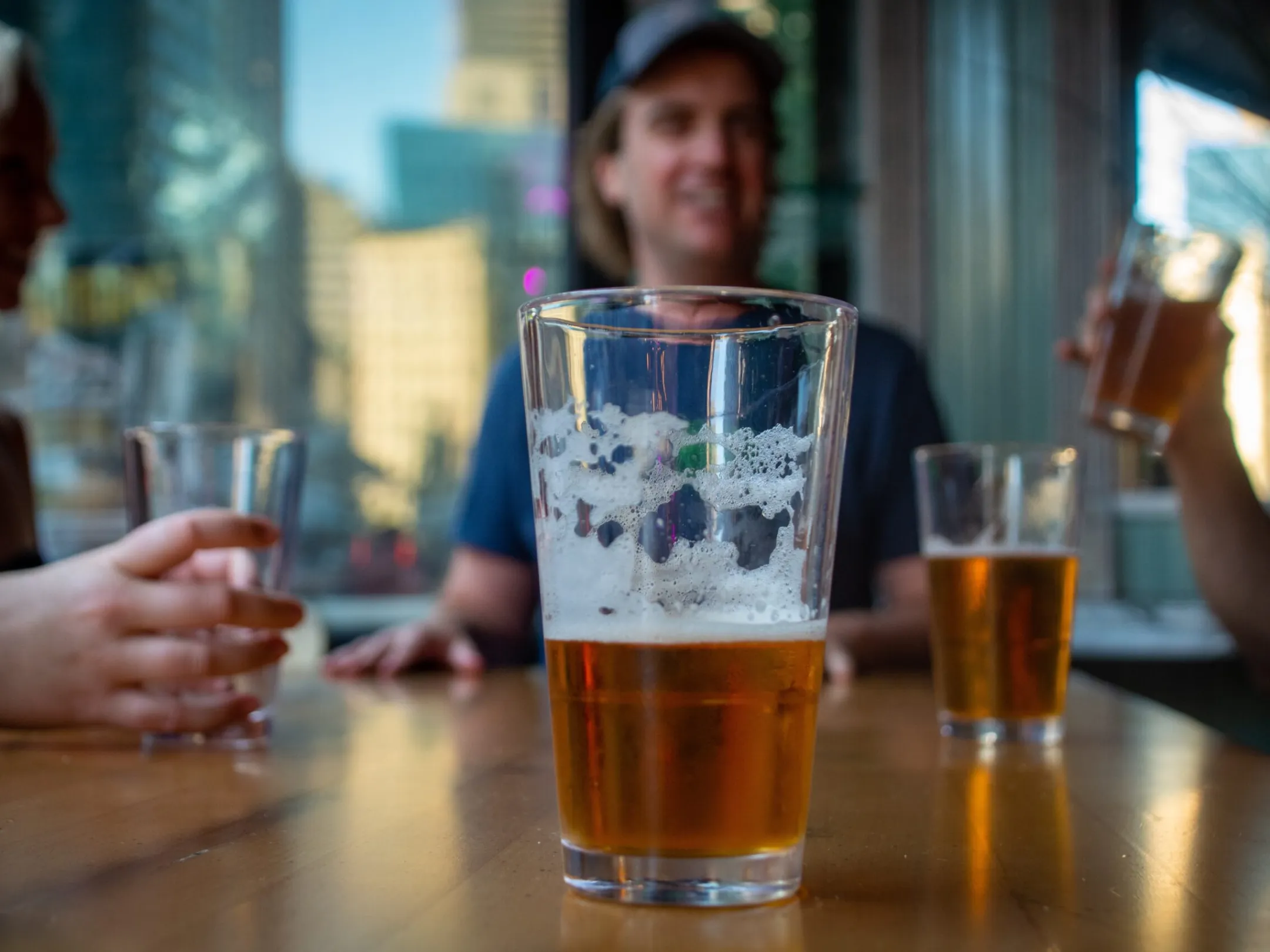 a person sitting at a table with a glass of beer