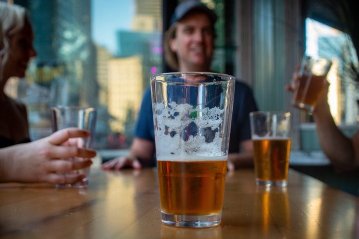 a person sitting at a table with a glass of beer