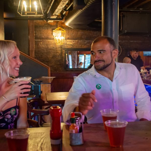 a person sitting at a table drinking wine at a restaurant